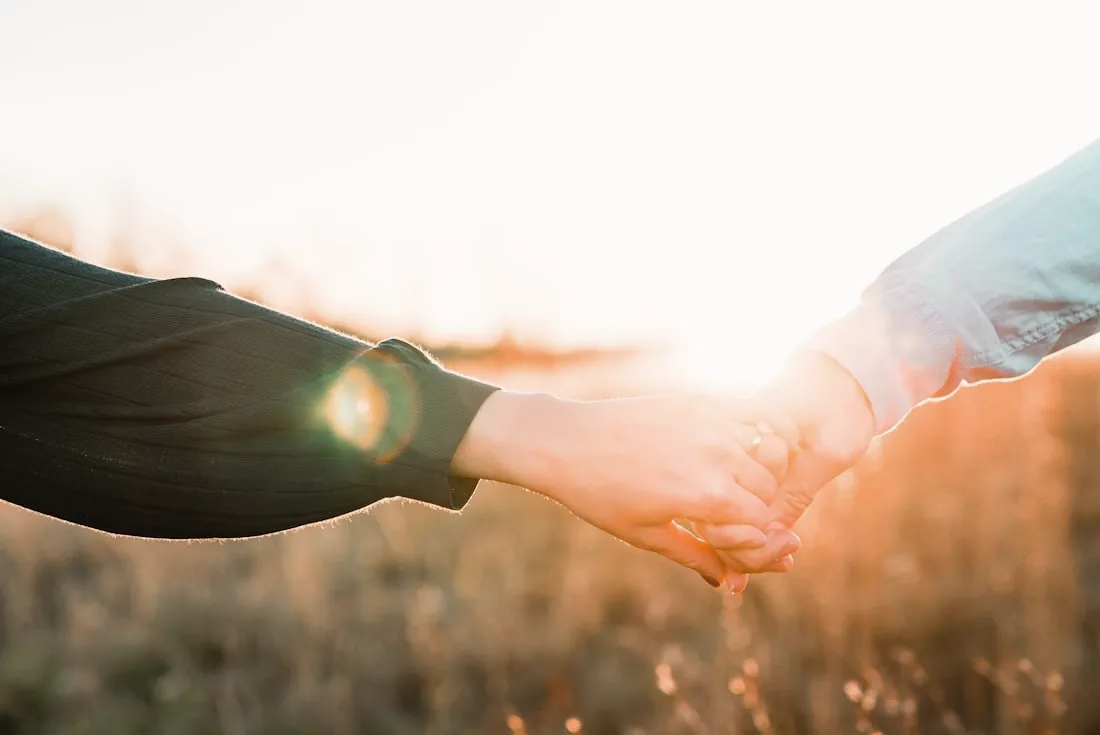 Two people holding hands at golden hour